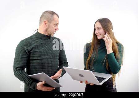 diverse partners sitting at table mature Latin business man and European business woman discussing project on laptop in office. Two colleagues of professional business . Office man woman laptops Stock Photo