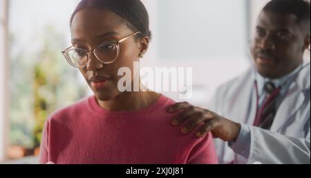 Portrait of a Professional Black Physician Using Stethoscope to Diagnose Any Lung Issue of a Recovering Young African Patient that Came for Check Up to a Modern Hospital After a Successful Surgery Stock Photo