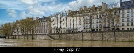 Panoramic view of historic buildings along the Seine River in Paris, France with a cloudy sky. Stock Photo