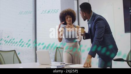Image of graphs, numbers over diverse coworkers discussing reports on laptop and drinking coffee. Digital composite, multiple exposure, business, team Stock Photo