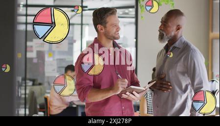 Image of multiple pie graph icons over two diverse men smiing while discussing at office. Computer interface and business technology concept Stock Photo