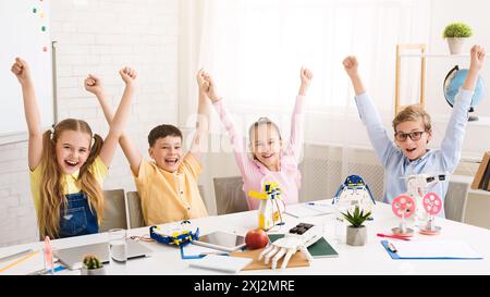 Excited Children Celebrate Successful Robotics Project in Classroom Stock Photo
