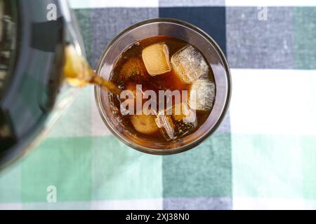 Cold Americano Coffee in a Takeaway Cup for Mockup use. Cold Coffee with Straw and Ice in a Cafe Stock Photo
