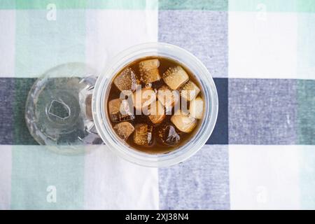 Cold Americano Coffee in a Takeaway Cup for Mockup use. Cold Coffee with Straw and Ice in a Cafe Stock Photo