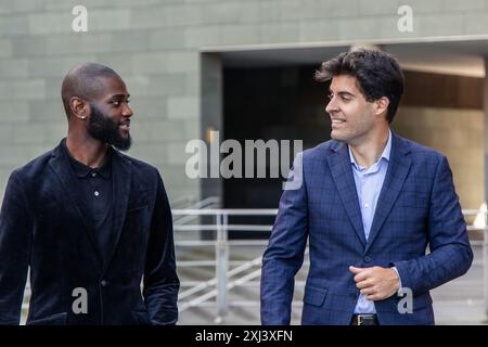 closeup African businessman and his Hispanic colleague in suits engaged in conversation while walking to their workplace in the downtown area. This sc Stock Photo