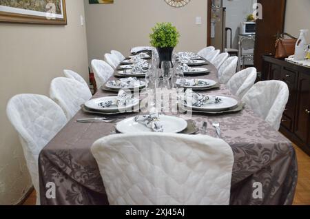 Fancy Dinner table set in dining room, prepared table for celebration at home, long dining table, indoors event, special occasion Stock Photo