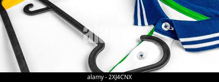 Casual white polo shirt with black wardrobe hanger close up Stock Photo