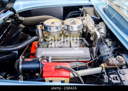 Open hood of blue 1957 Chevrolet Corvette convertible sports car showing engine bay motor and components Stock Photo