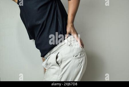 Man suffering from backache at front of beige background Stock Photo