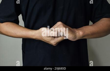Young deaf mute man using sign language on beige background Stock Photo