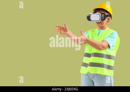 Mature female worker using VR glasses on green background Stock Photo