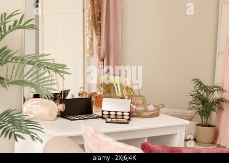 Makeup products on table in dressing room Stock Photo