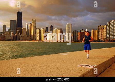 An adult man maintains his healthy lifestyle along the lakeshore in Chicago Stock Photo