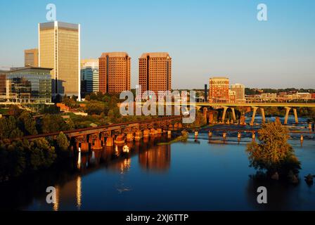 The skyline of Richmond Virginia rises along the James River and is reflected in the calm water Stock Photo