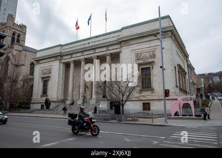 The stunning facade of the Montreal Museum of Fine Arts in downtown Montreal, Canada, stands majestically, with a sleek motorcycle driving in front, b Stock Photo