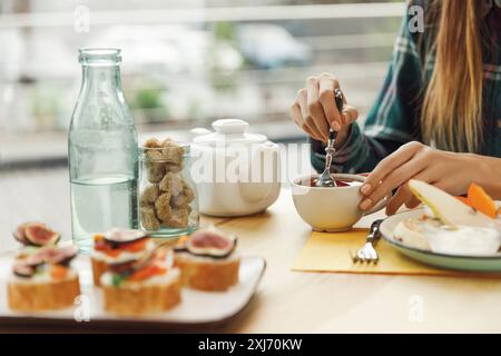 cropped shot of girl drinking tea while having breakfast Stock Photo