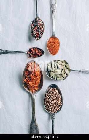 top view of indian spices in spoons on white table Stock Photo
