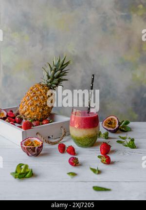 Organic layered fruit smoothie on wooden background with exotic fruits Stock Photo