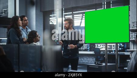 Team of Diverse South Asian Information Technology Experts Having a Meeting in a Conference Room with Green Screen Mock Up Display. Team Leader Making a Presentation for Project Managers at the Office Stock Photo
