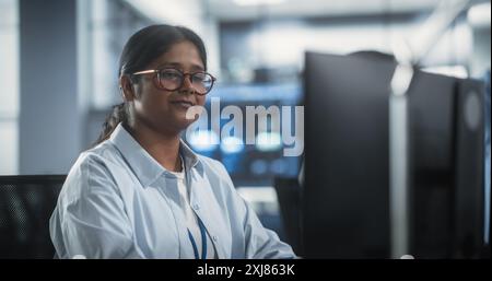 Portrait of a Smart Focused South Asian Engineer Working on Computer in a Technological Corporate Office. Young Woman Developing Software for an Innovative Internet Service Provider Stock Photo