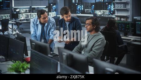 Team of Three Multiethnic Diverse Software Developers Talk, Discuss and Collaborate on an AI Project. Empowered Young Indian Specialists Work on Digital E-Commerce Startup Business Stock Photo