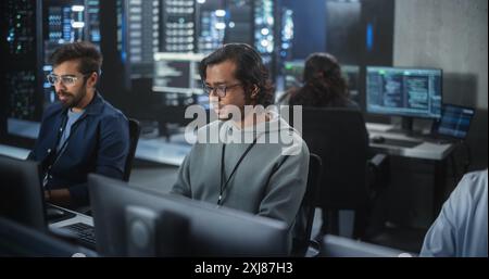 Portrait of a Handsome Indian Engineer Working on Desktop Computer in a Technological Office Environment. Research and Development Department Writing Software Code for an Innovative Internet Project Stock Photo