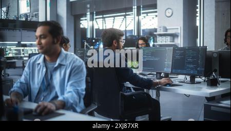 Team of Talented Young Indian Professionals Working in a Technological Research and Development Agency. Computer Screens with Software Code and Technical Neural Network Diagrams Stock Photo
