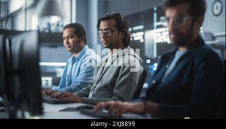 Young Passionate Specialist Working on Computer, Programming a Software for an Innovative Technological Internet Product Launch. Diverse Indian Team Working in a Startup Agency Stock Photo