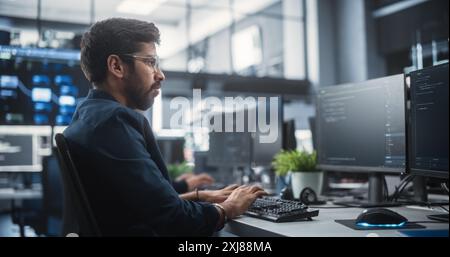 Young Creative Manager Using Computer, Writing a Project Plan for an Innovative Technological Internet Product Launch. Diverse Multicultural Team Working in a Startup Company Stock Photo