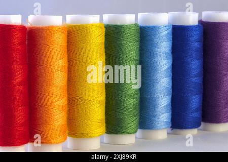 Rainbow colour sewing threads on white background Stock Photo