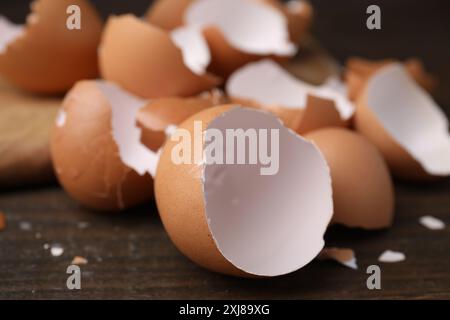 Pieces of broken eggshells on wooden table, closeup Stock Photo