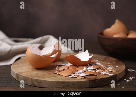 Pieces of broken eggshells on wooden table, closeup Stock Photo