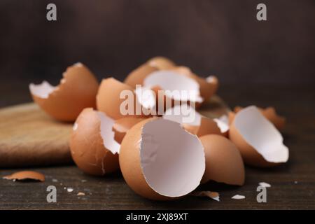 Pieces of broken eggshells on wooden table, closeup Stock Photo