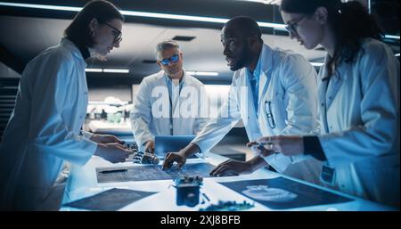 Diverse Team of Industrial Robotics Specialists Working on Innovative Prosthetic Hands in Advanced Research Facility. Young Engineers Discussing the Prototype, Testing Electronic Details. Stock Photo
