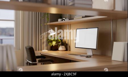 A computer with a white-screen mockup on a wooden desk features illumination from a table lamp, books, and houseplants in a cozy home office. place of Stock Photo