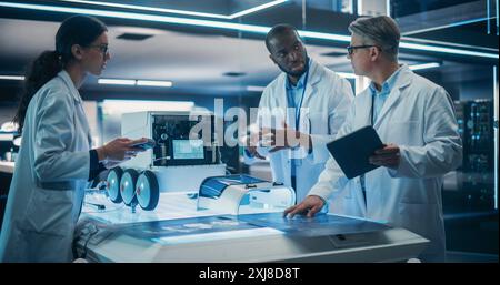 Portrait of a Diverse Team of Industrial Robotics Specialists Working on a Mobile Robot. Engineers In Lab Coats Discussing an Automated Robotic Delivery Assistant with Artificial Intelligence Stock Photo