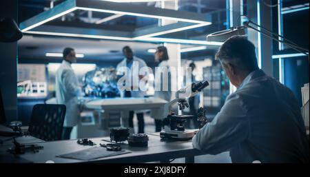Smart Team of Engineers, Project Manager and Machinery Operators Collaborate on New Type of a Electric Turbine Engine, Using Tablet Computer and Digital Microscope in Scientific Technology Lab. Stock Photo