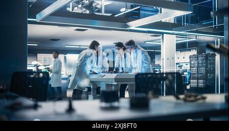 Young Team of Smart Diverse Multicultural Engineers Building and Developing a Prosthetic Artificial Intelligence Powered Robot Arm. High Tech Research Factory with Talented Professional Employees Stock Photo