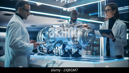 Smart Team of Engineers, Tech Scientist and Machinery Operators Collaborate on a New Type of a Electric Turbine Engine, Using Computers and Measuring Tools in Scientific Technology Lab Stock Photo