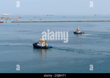 Callao, Peru - March 20, 2019: Tugboats navigate serene waters off Peruvian coast. Stock Photo