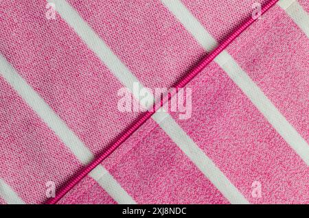 Closeup view of zip hoodie fabric texture. Pink zip hoodie fabric with white stripes pattern. Stock Photo