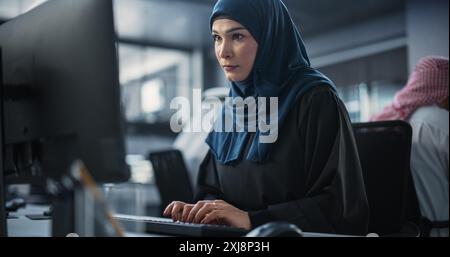 Portrait of a Smart Focused Middle Eastern Engineer Working on Computer in a Technological Corporate Office. Young Arab Woman Developing Software for an Innovative Internet Service Provider Stock Photo