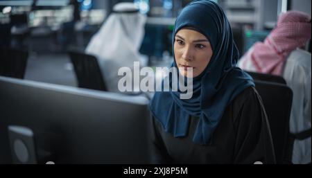 Portrait of a Thoughtful Middle Eastern Engineer Working on Computer in a Technological Corporate Office. Young Woman Writing Software Code for an Innovative Internet and Software as a Service Project Stock Photo