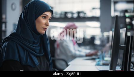 Portrait of a Thoughtful Middle Eastern Engineer Working on Computer in a Technological Corporate Office. Young Woman Writing Software Code for an Innovative Internet and Software as a Service Project Stock Photo