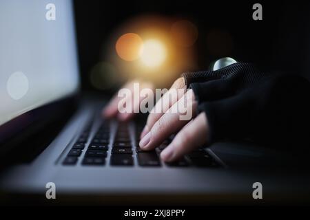 Hacker, typing and hands of person on computer for malware virus, online banking fraud and identity theft. Cybersecurity, night and thief on laptop Stock Photo