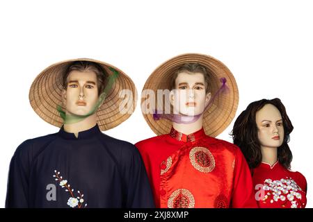 Male and female mannequins dressed in Vietnamese traditional clothes at street market. Cultural heritage. Mannequins with Vietnamese conical hats and Stock Photo