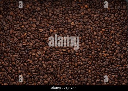 A close-up of roasted coffee beans, showcasing their rich texture and deep brown color, perfect for coffee lovers and gourmet promotions. Stock Photo