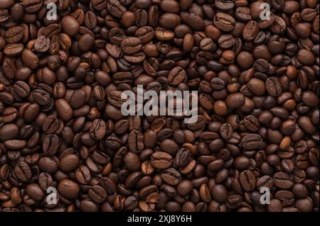 A close-up of roasted coffee beans, showcasing their rich texture and deep brown color, perfect for coffee lovers and gourmet promotions. Stock Photo