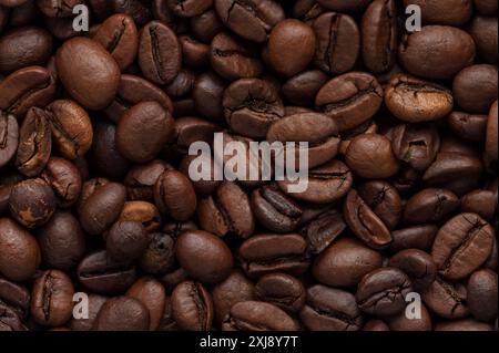 A close-up of roasted coffee beans, showcasing their rich texture and deep brown color, perfect for coffee lovers and gourmet promotions. Stock Photo