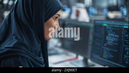 Portrait of a Smart Focused Middle Eastern Engineer Working on Computer in a Technological Corporate Office. Young Arab Woman in Hijab Developing Software for an Innovative Internet Service Provider Stock Photo